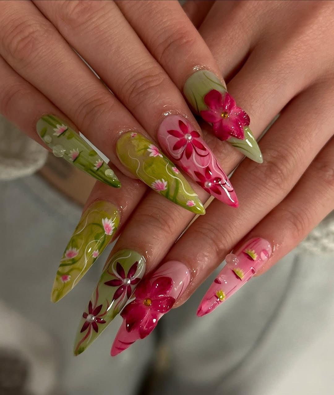 Long press-on nails with green and pink floral designs and 3D flower accents
