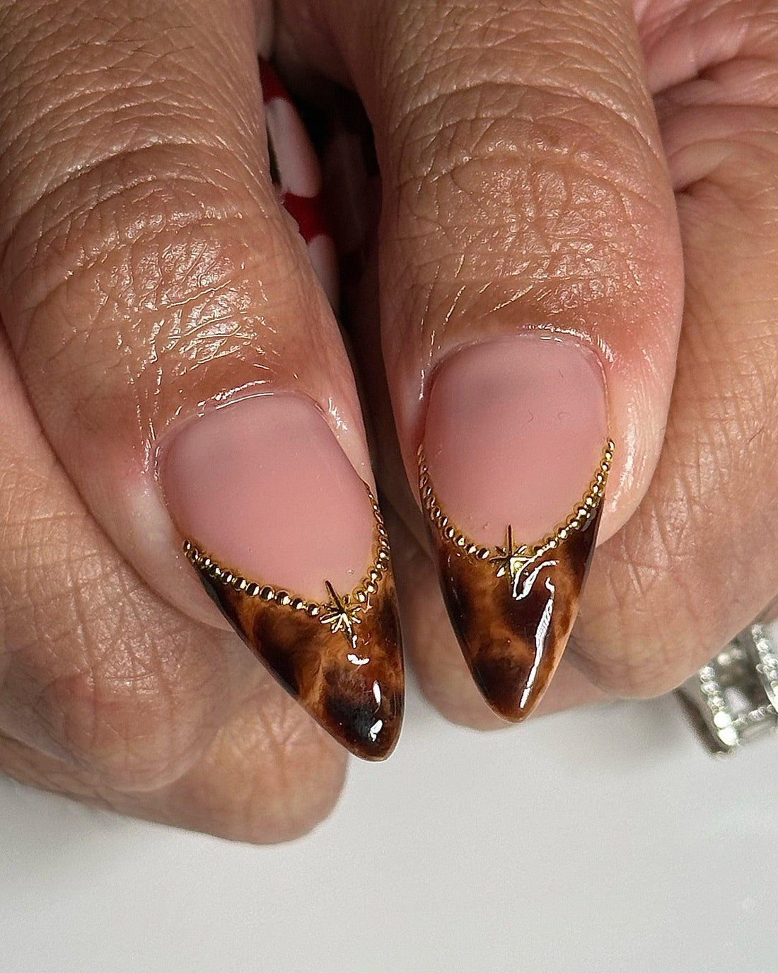 Stiletto press-on nails with cherry art, cross charms, brown marble tips and red abstract designs