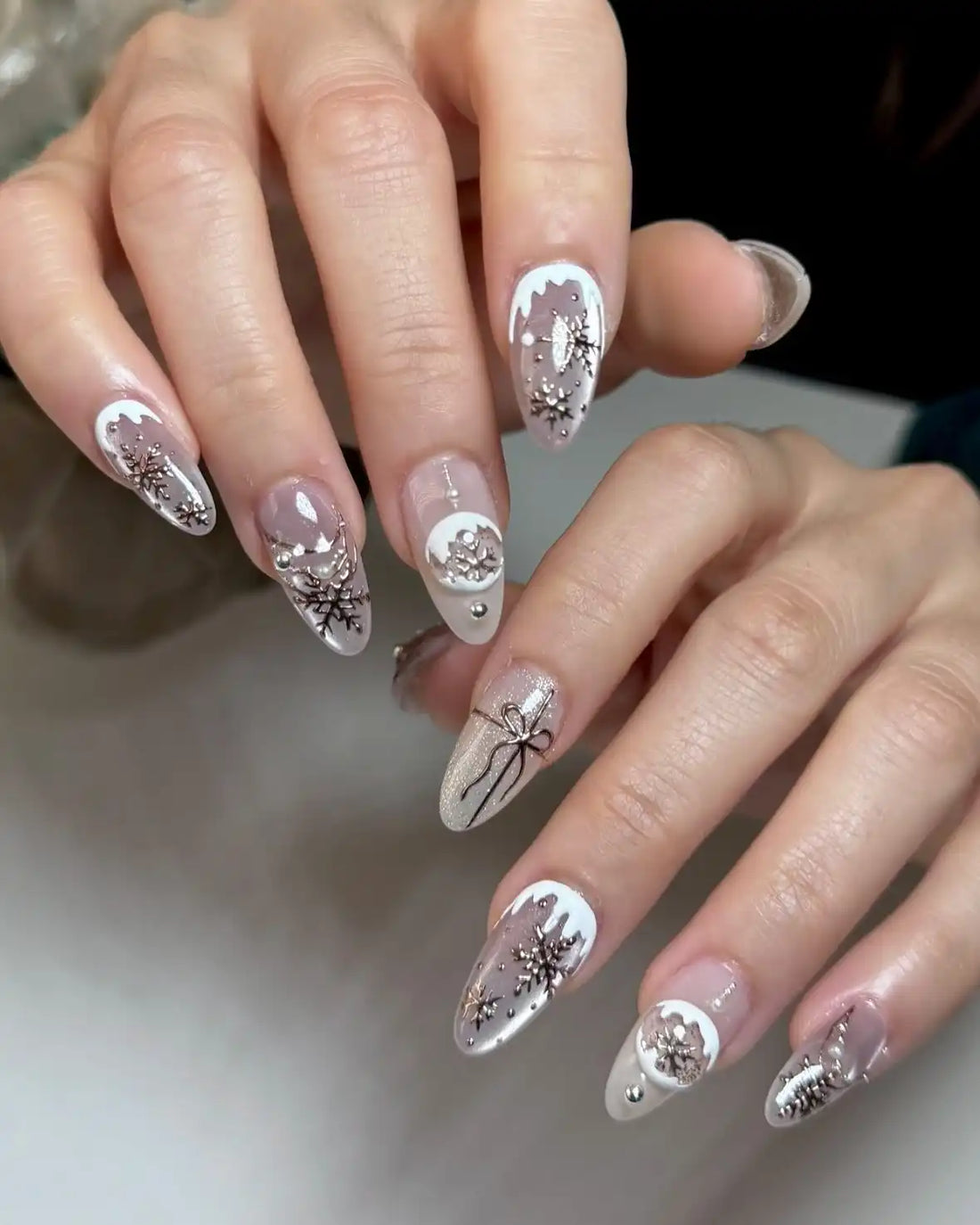Handmade press-on nails with white tips, snowflake designs and rhinestone accents
