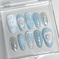 Winter-themed press-on nails with snowman designs, snowflakes, icicle patterns, and 'Let it Snow' text.