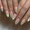 Light yellow French tip press-on nails with 3D floral and pearl accents, stiletto shape.