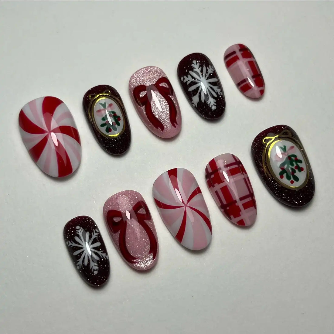 Handmade Christmas press-on nails with candy cane, plaid, bow, snowflake, and holly designs