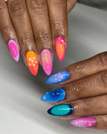 Hand with colorful handmade press-on nails, hibiscus flower art, glossy spring design