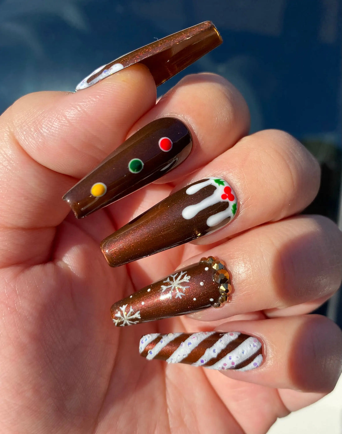 Brown Christmas gingerbread-themed press-on nails with snowflakes and candy cane designs.