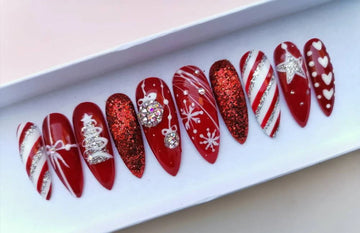 Red Christmas press-on nails with glitter, candy cane stripes, snowflakes, and festive designs