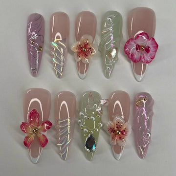 Handmade press-on nails with 3D floral designs, rhinestones, and iridescent accents.