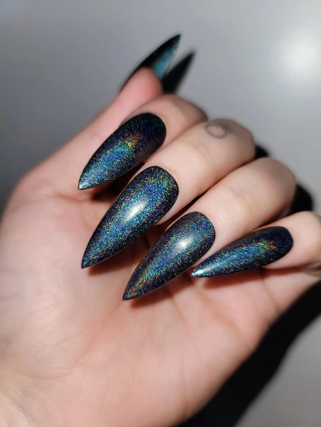 Hand with long stiletto galaxy holographic handmade press-on nails