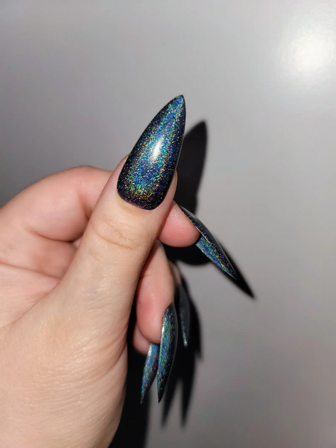 Hand with long stiletto galaxy holographic handmade press-on nails