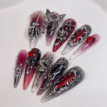 Long red and black press-on nails with silver gothic charms and 3D accents