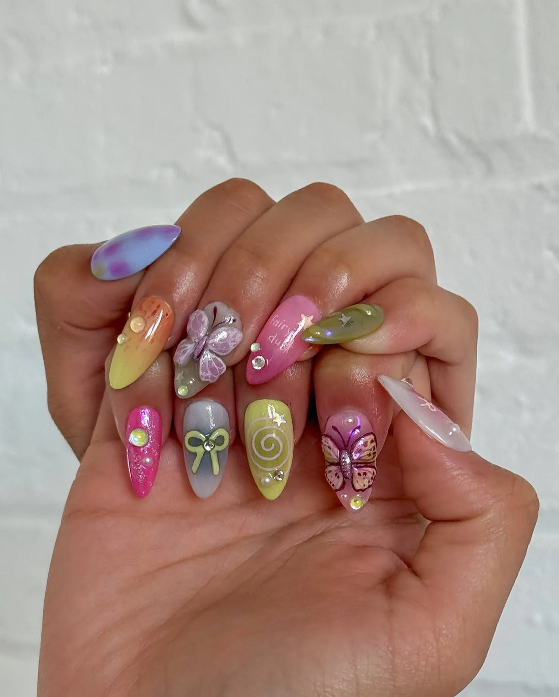 Handmade pastel ombre press-on nails with 3D butterfly, bow, and fairycore designs, glitter accents