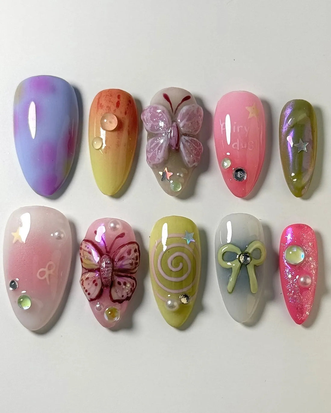 Handmade pastel ombre press-on nails with 3D butterfly, bow, and fairycore designs, glitter accents