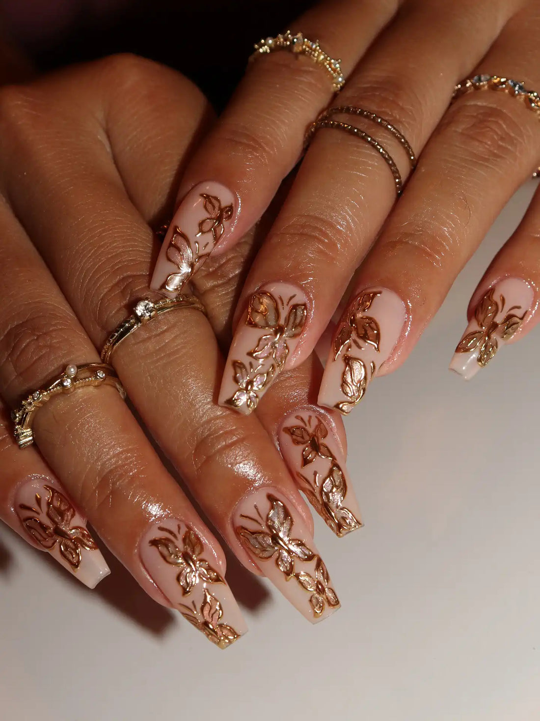 Handmade nude press-on nails with 3D gold chrome butterfly and floral designs