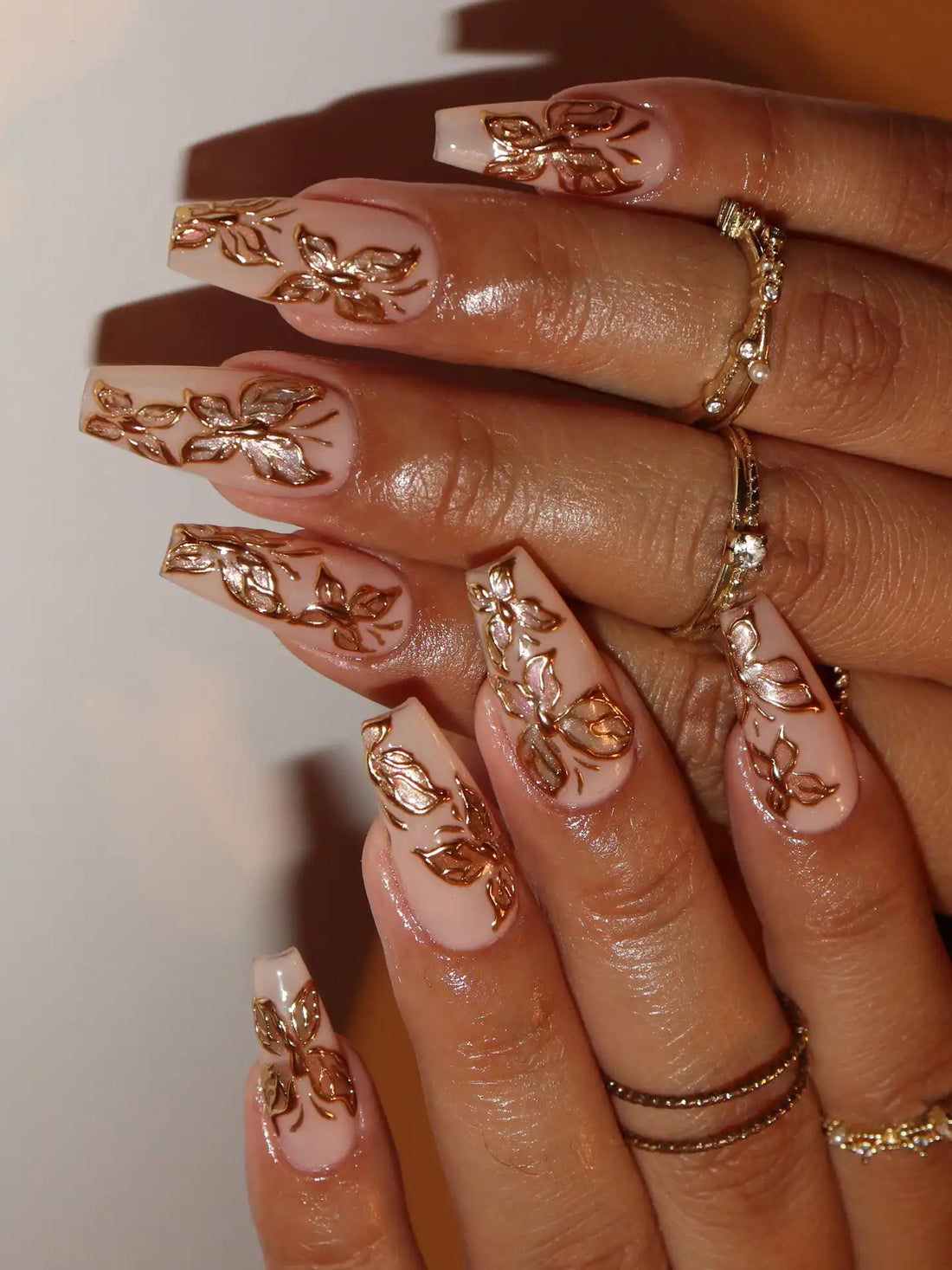 Handmade nude press-on nails with 3D gold chrome butterfly and floral designs