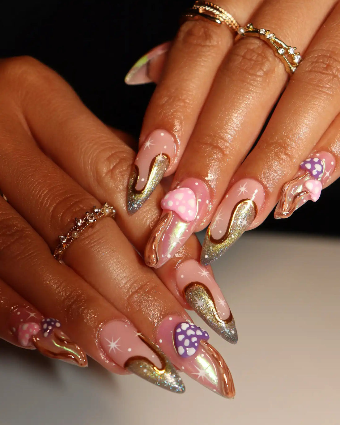 Hand with pink chrome 3D mushroom press-on nails, stardust and whimsical goth accents
