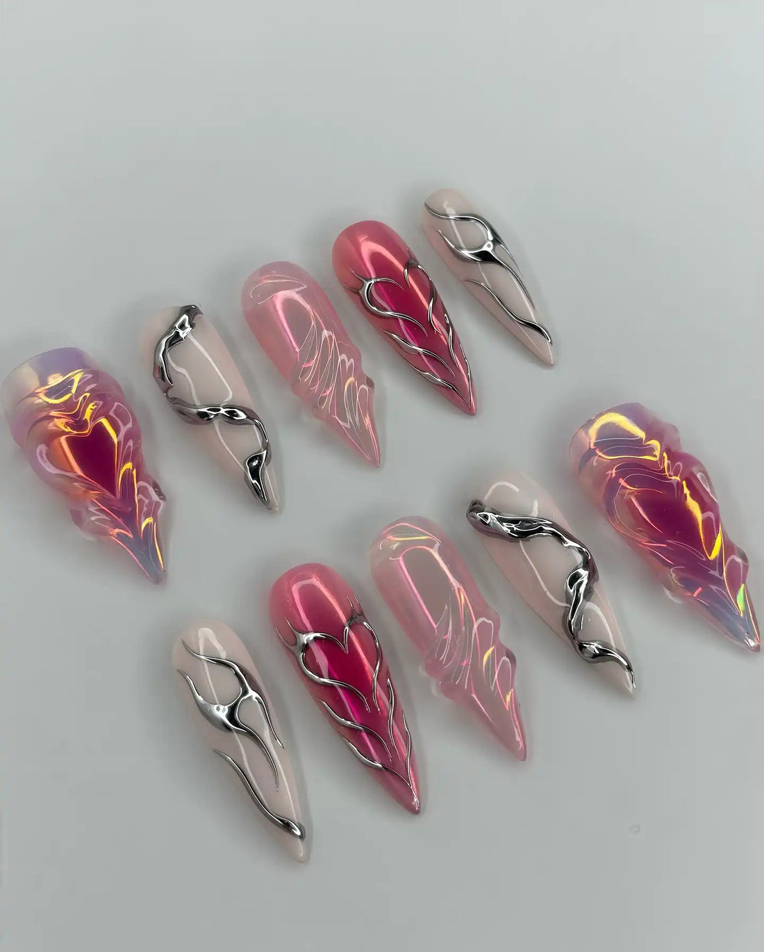 Handmade pink chrome press-on nails with heart, snake, and grunge Y2K designs.