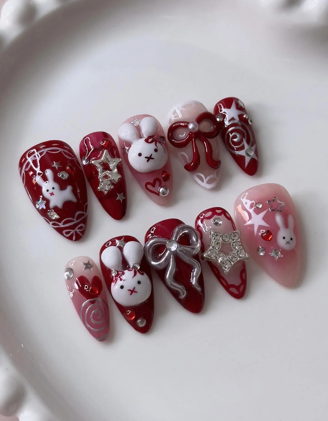 Handmade red press-on nails with 3D bunny, bow, and star kawaii holiday designs