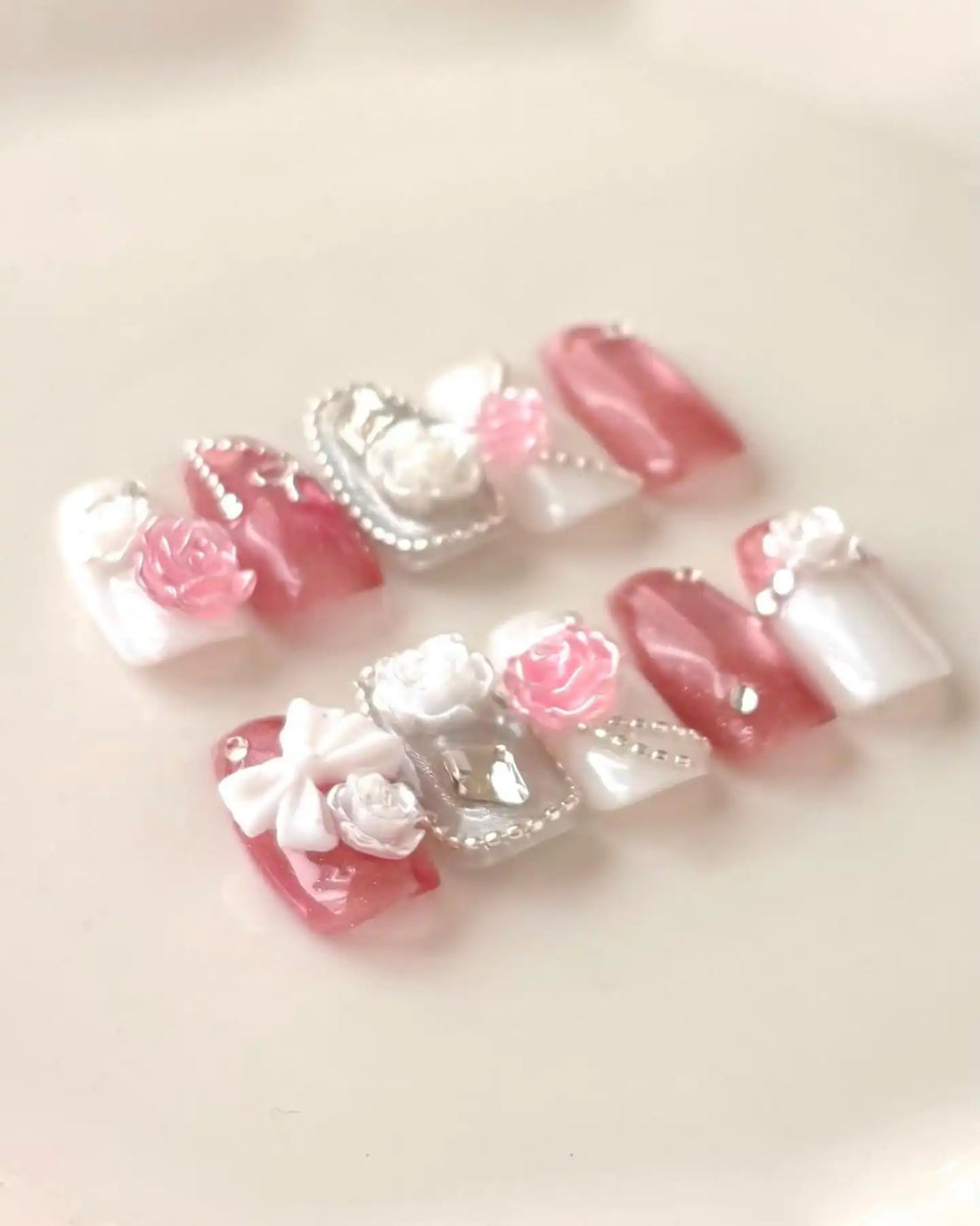 Handmade pink and white coffin press-on nails with 3D rose, bow, and rhinestone accents.