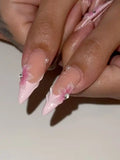 Hand with long pink French tip press-on nails, 3D floral accents and pearl details