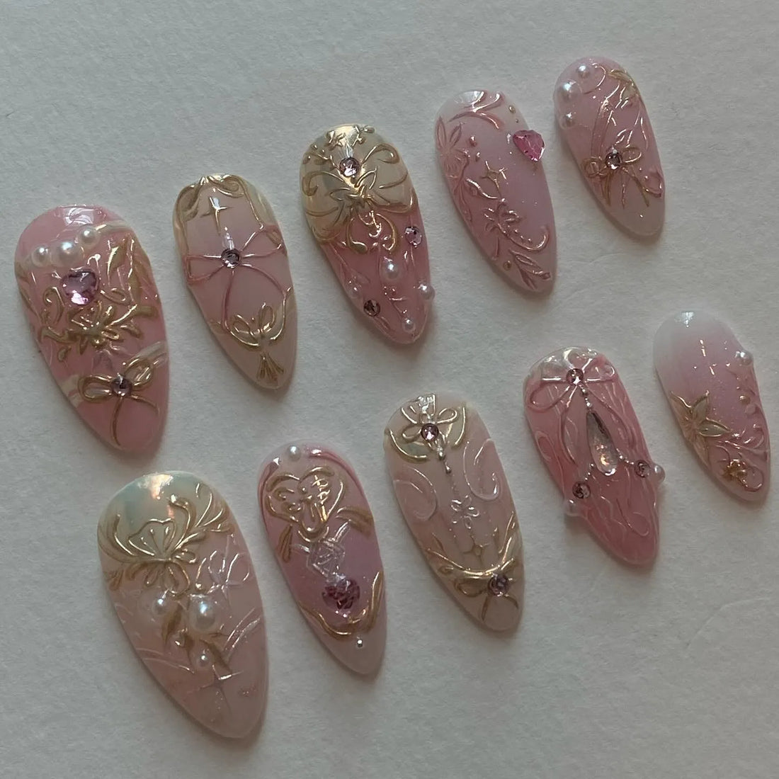 Handmade pink press-on nails with gold baroque filigree, rhinestones, and pearl accents