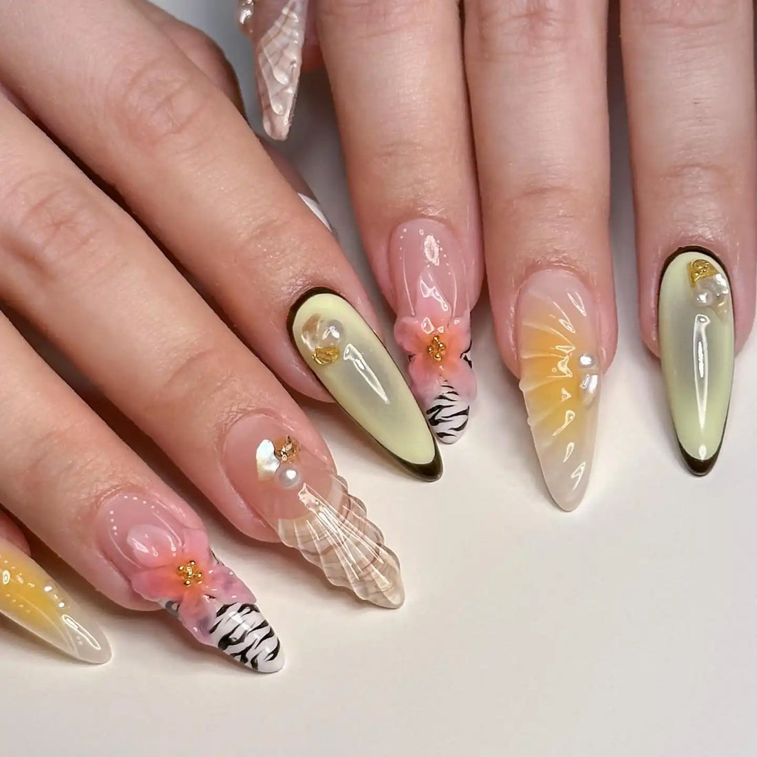 Handmade press-on nails with seashell, floral, and zebra patterns in pastel colors