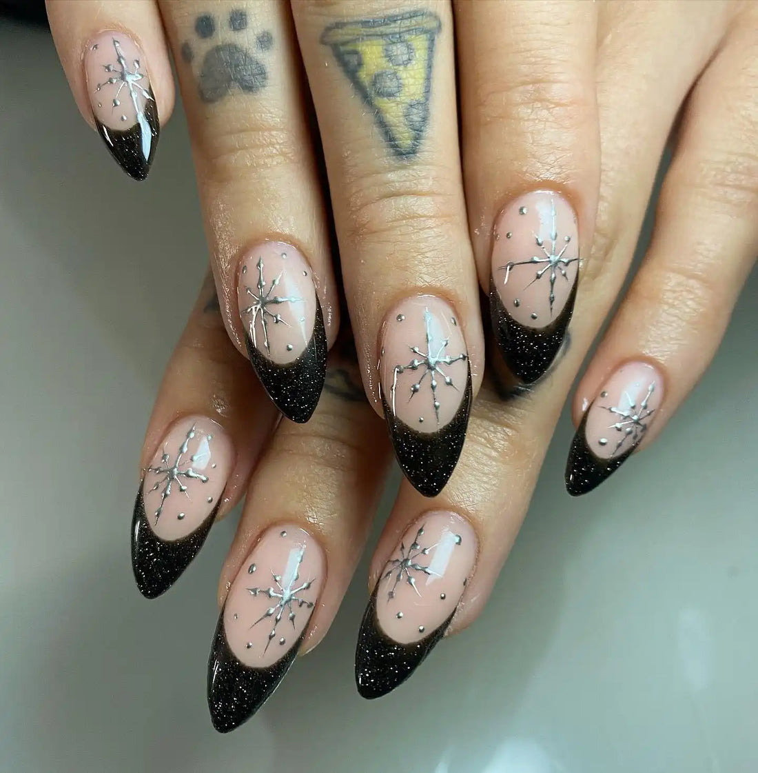 Handmade black glitter French tip press-on nails with silver starburst design