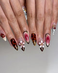 Handmade press-on nails with cherry brown, white floral designs, tortoiseshell, and zebra art