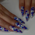 Handmade stiletto press-on nails with blue and purple watercolor floral designs and gold accents