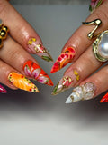 Handmade press-on nails with bold red, orange, and gold 3D floral and butterfly designs.