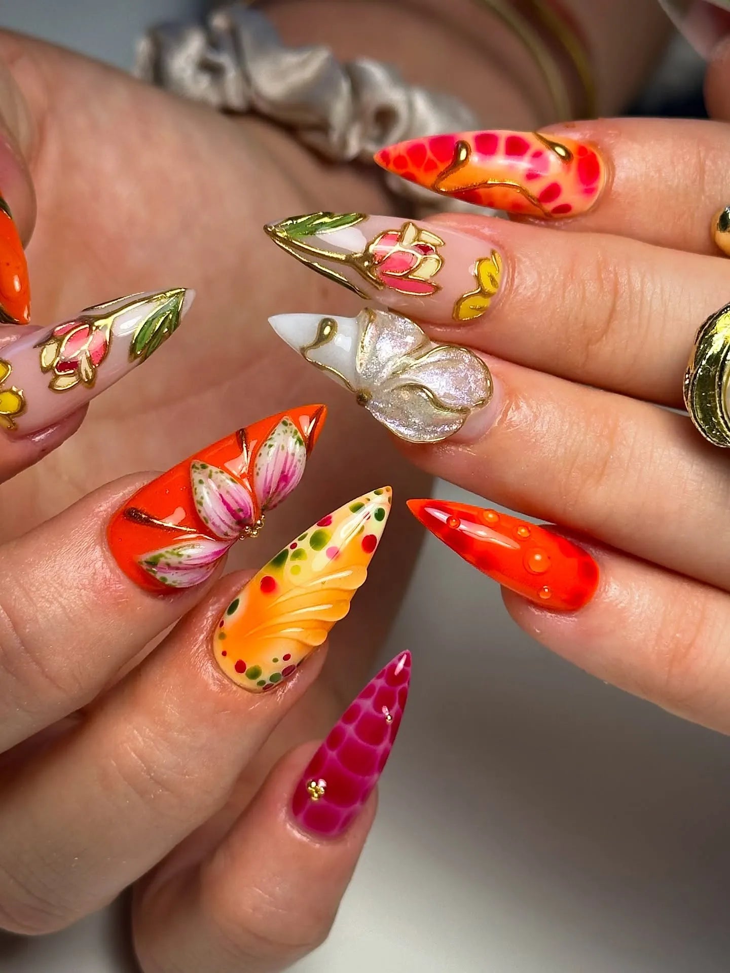 Handmade 3D floral butterfly luxury press-on nails in bold red, orange, and gold designs.