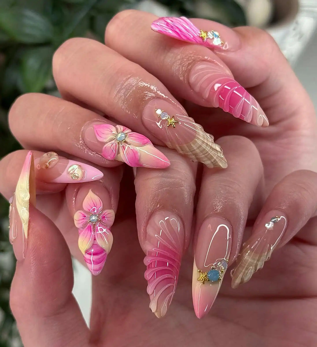 Handmade press-on nails with pink 3D floral and seashell designs, crystal accents, glossy finish.