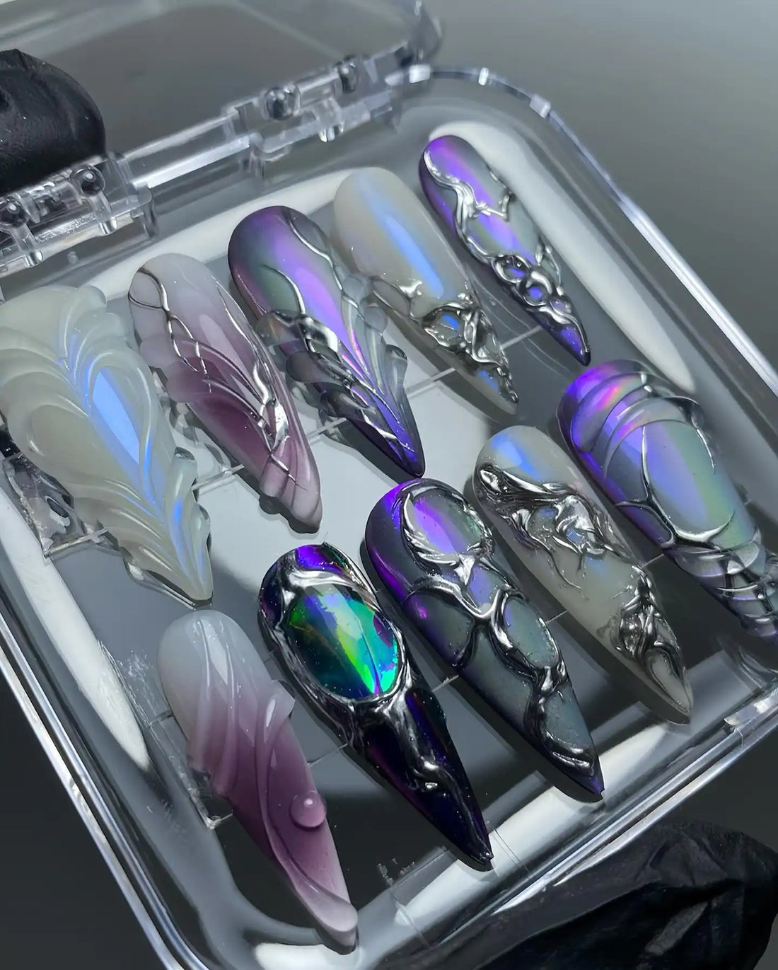 Handmade press-on nails with chrome, black, and iridescent purple abstract sci-fi designs
