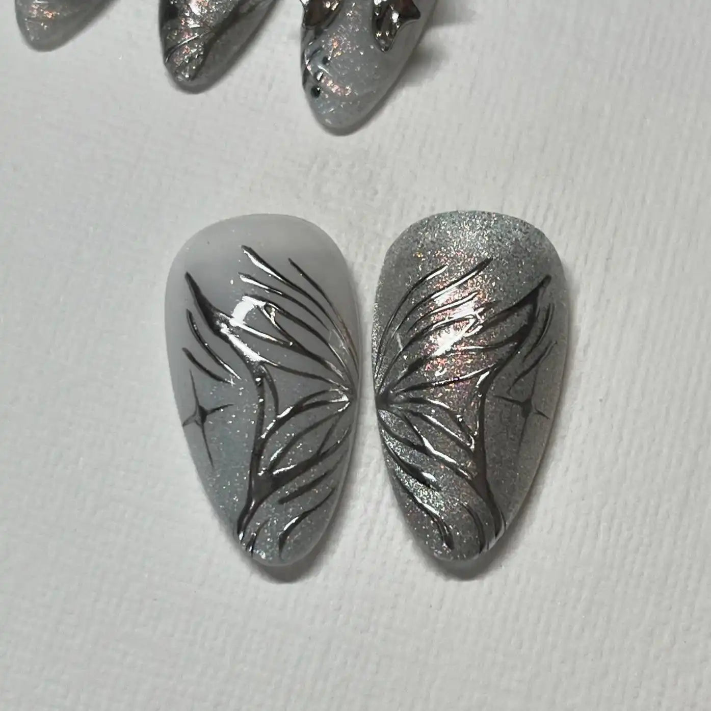 Handmade chrome silver press-on nails with abstract butterfly wing design
