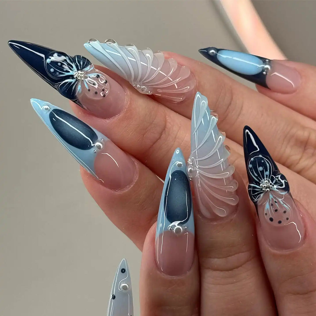 Handmade stiletto press-on nails with clear floral designs in black and light blue.