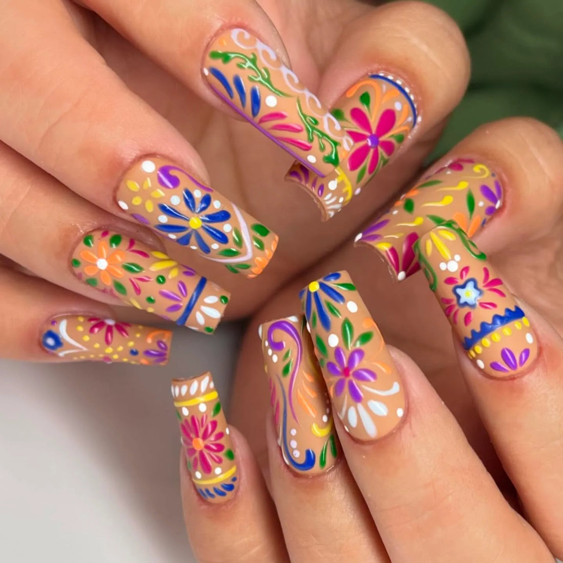 Handmade press-on nails with vibrant, colorful folk art floral summer designs.