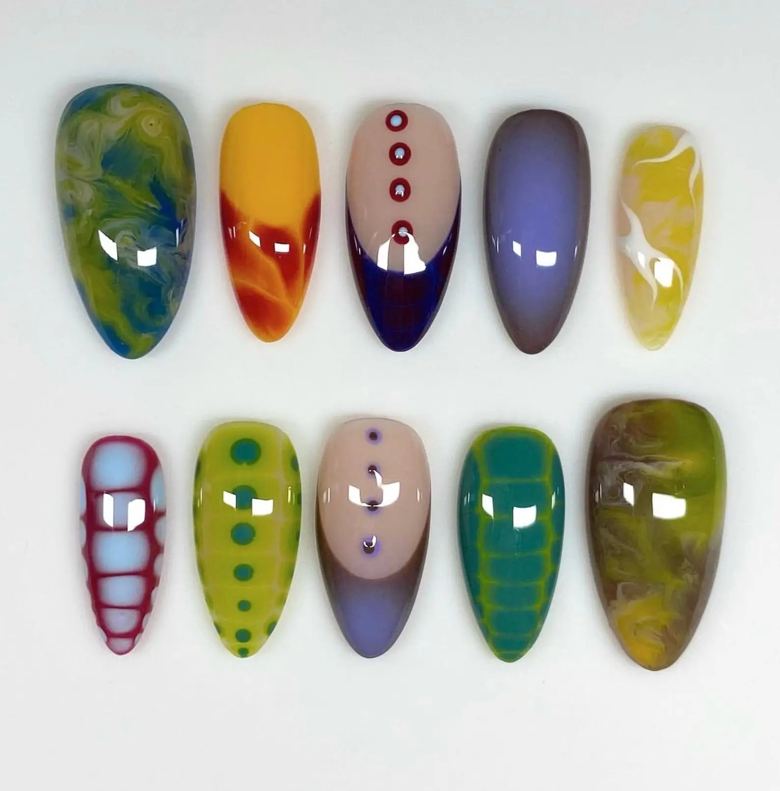 Handmade colorful graffiti press-on nails with abstract and geometric patterns on white background