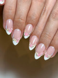 Handmade press-on nails with pearl white French tips and pink floral garden design.