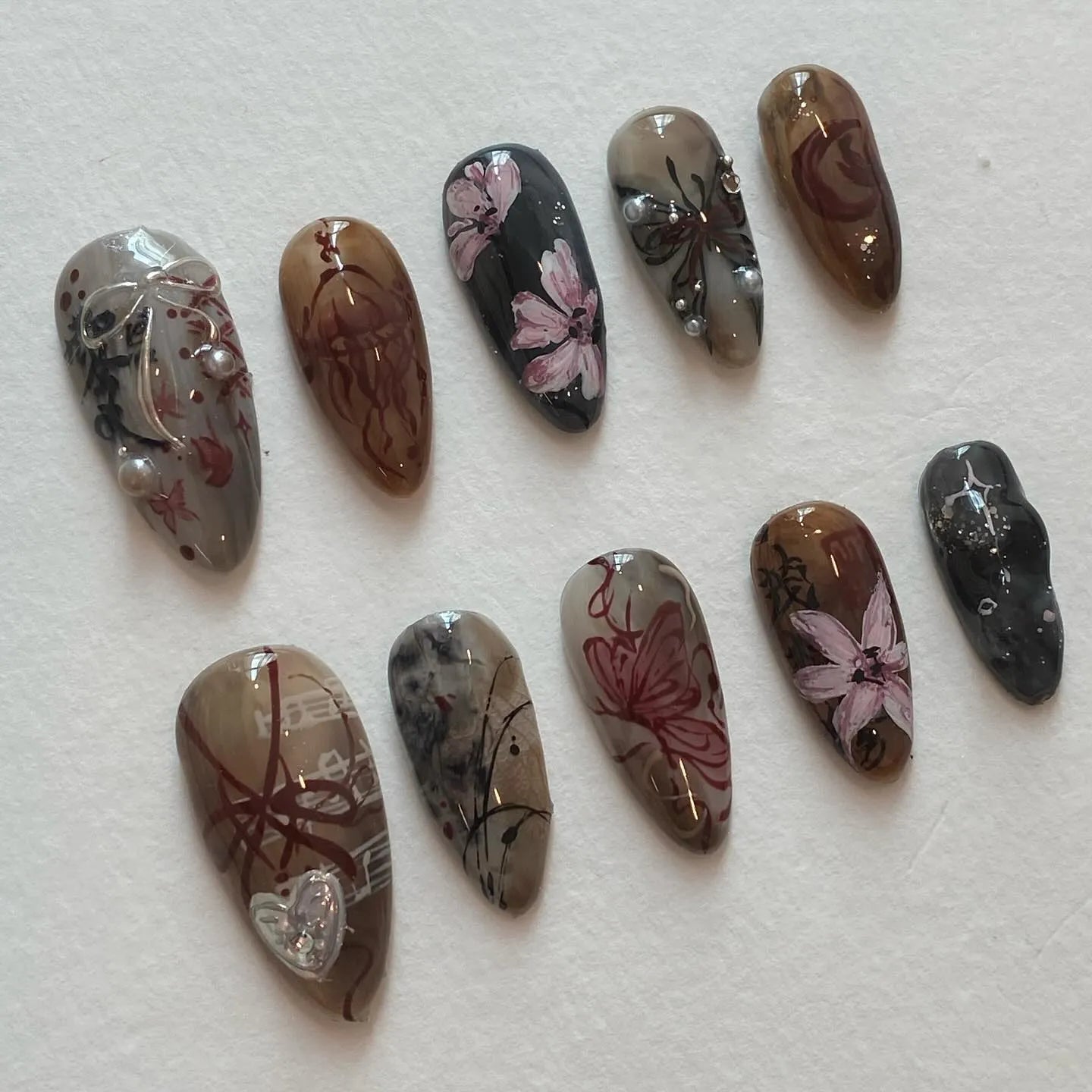 Handmade press-on nails with dark academia floral and butterfly designs in brown and gray tones.