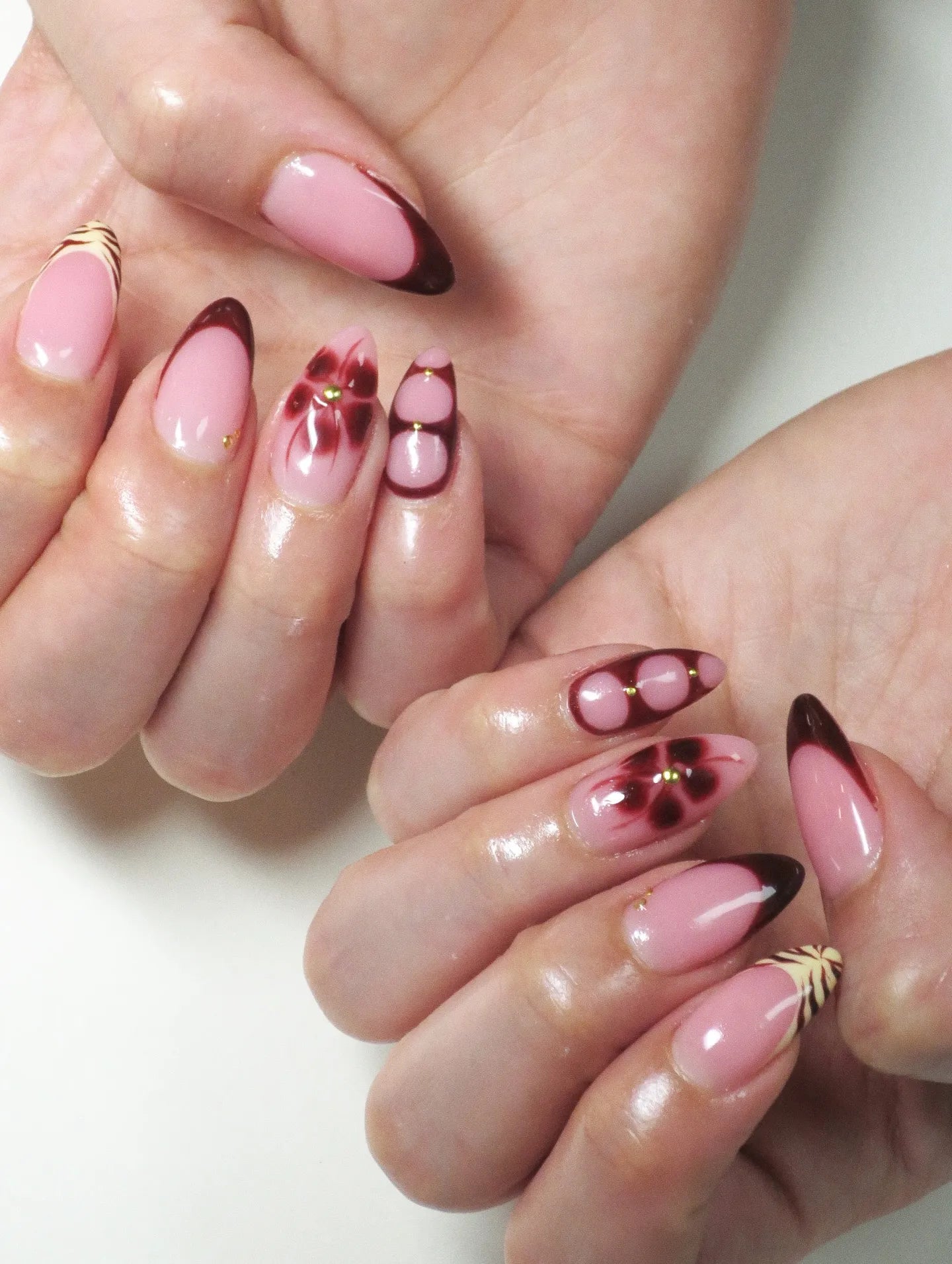 Handmade press-on nails with dark cherry French tips, floral and tiger print accents