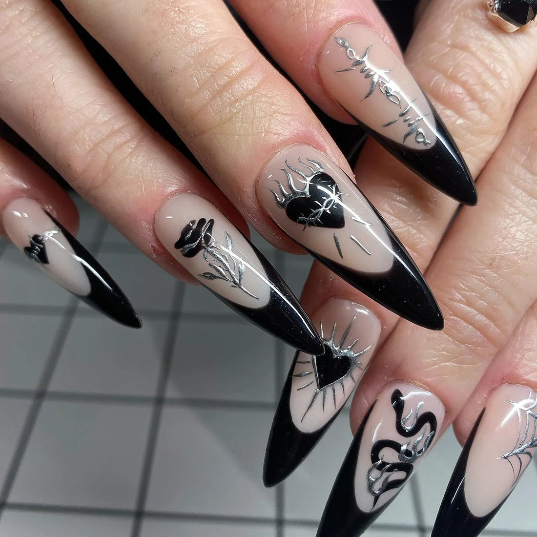Handmade gothic press-on nails with black French tips, heart, rose, spiderweb, and silver accents.