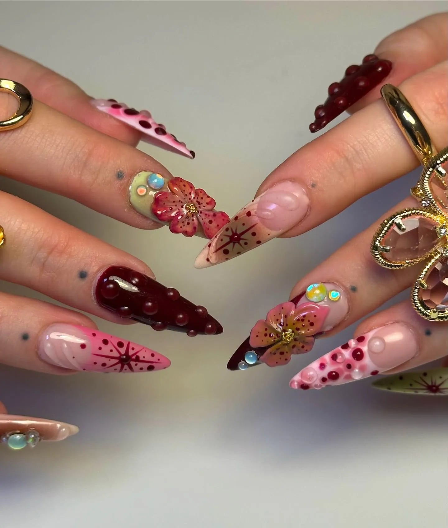 Handmade deep red 3D floral press-on nails with gemstones and artistic detailing