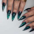 Handmade deep teal nebula press-on nails with silver metallic edges, stiletto shape