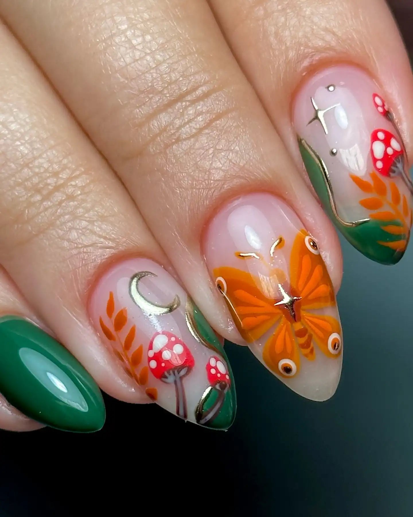 Handmade press-on nails with autumn butterfly, red mushrooms, moon, and forest leaf designs.
