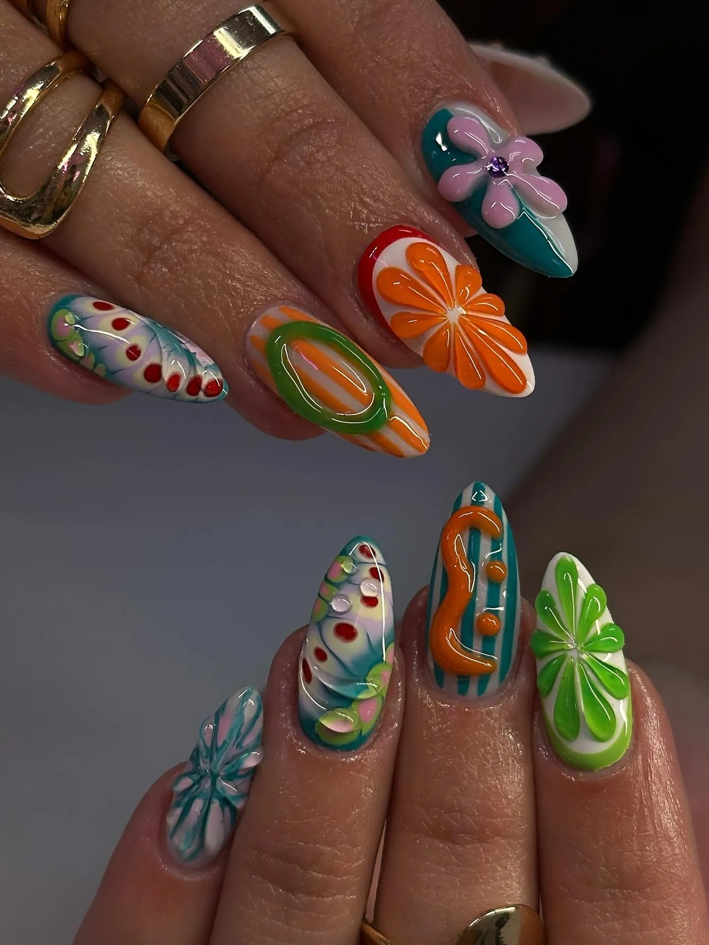 Handmade press-on nails with colorful abstract swirl, floral, and fruit summer designs.