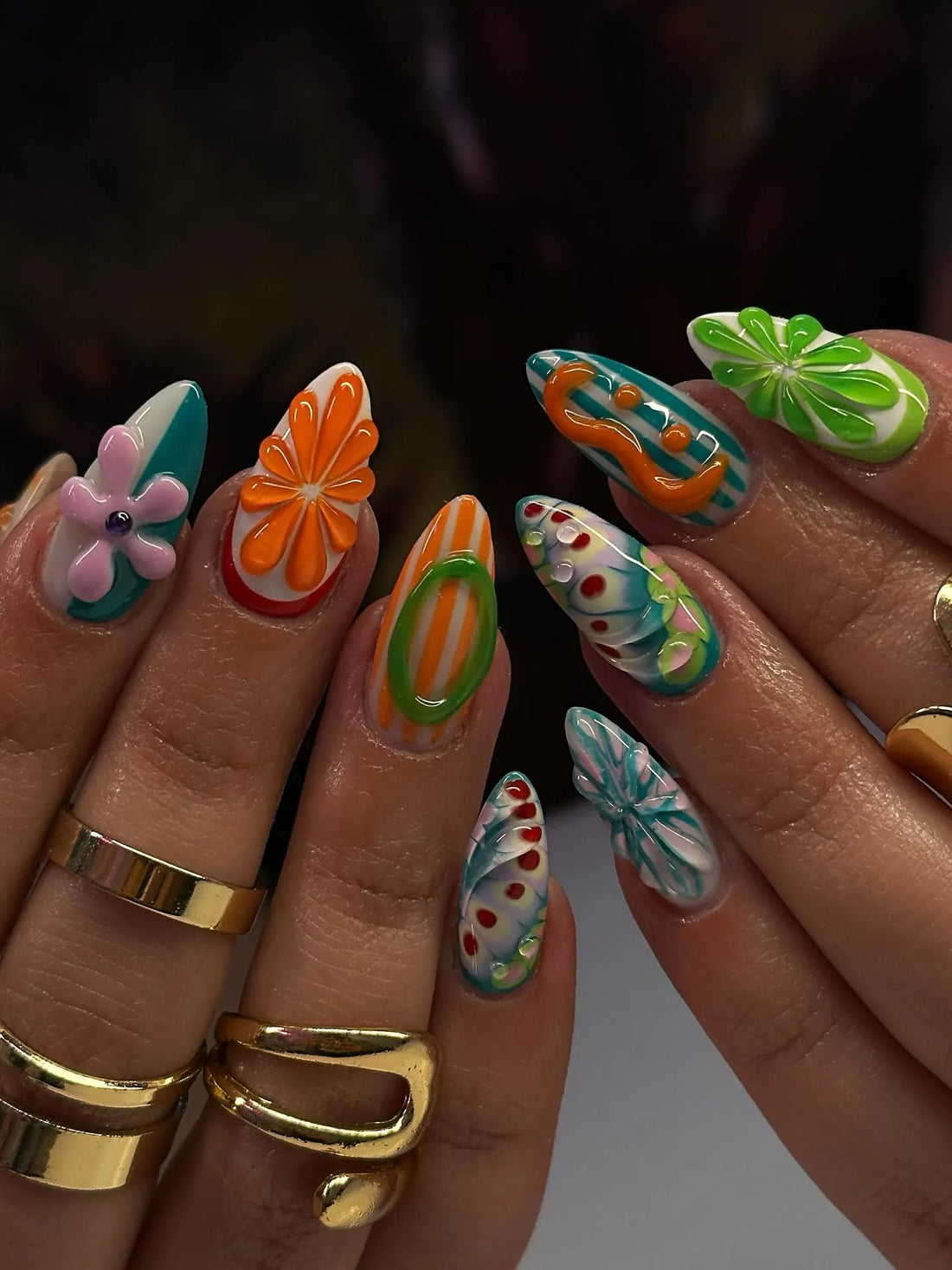 Handmade press-on nails with colorful abstract swirl, floral, and fruit summer designs.