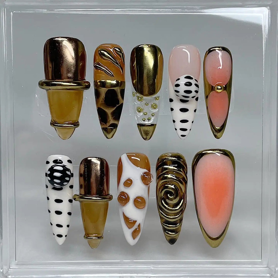 Handmade press-on nails with gold chrome, polka dots, giraffe pattern, and swirl accents.