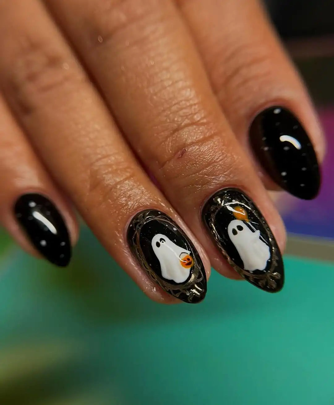 Handmade Halloween press-on nails with cute ghost designs and metallic accents on black base