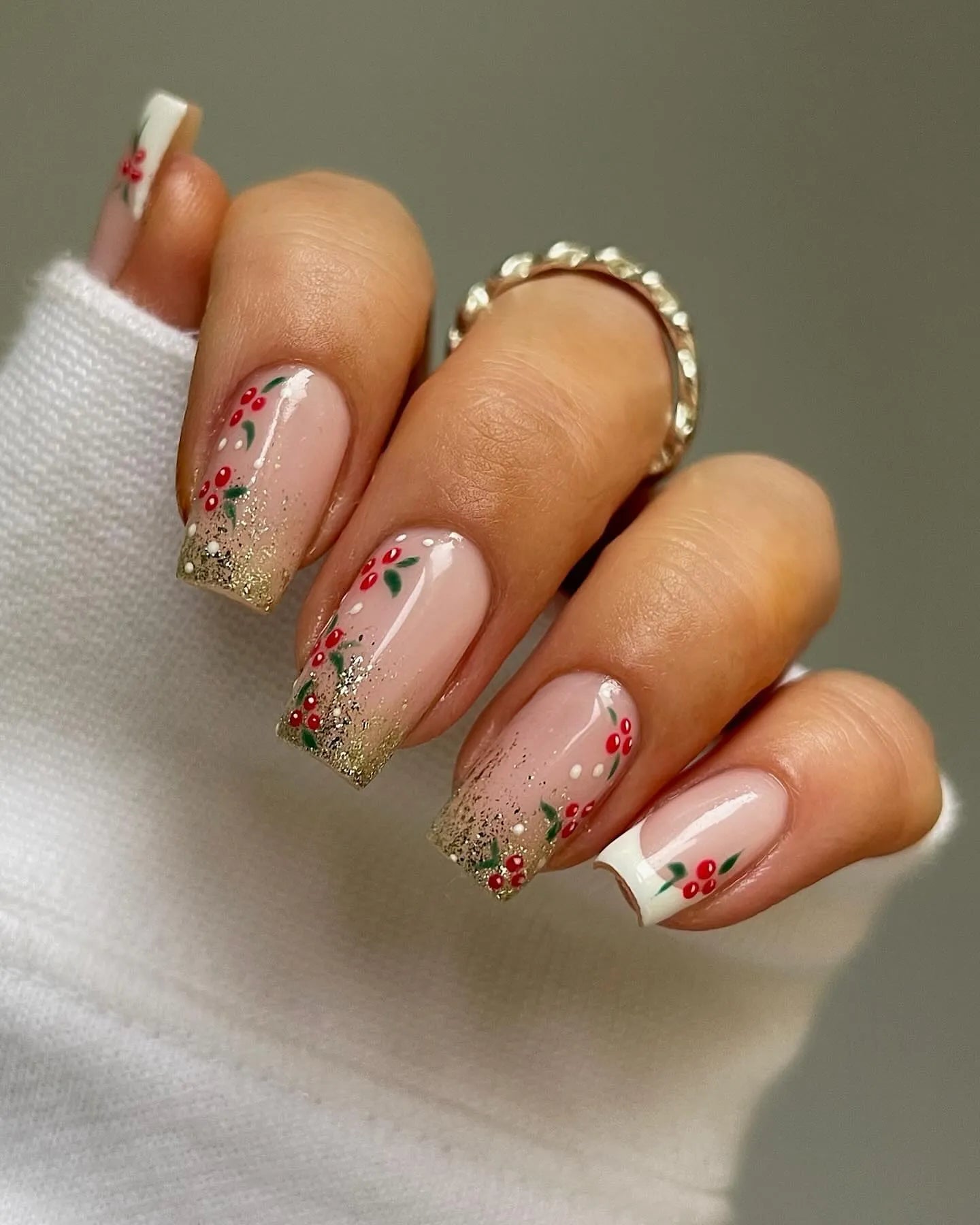 Handmade festive press-on nails with gold glitter tips and holly berry Christmas designs