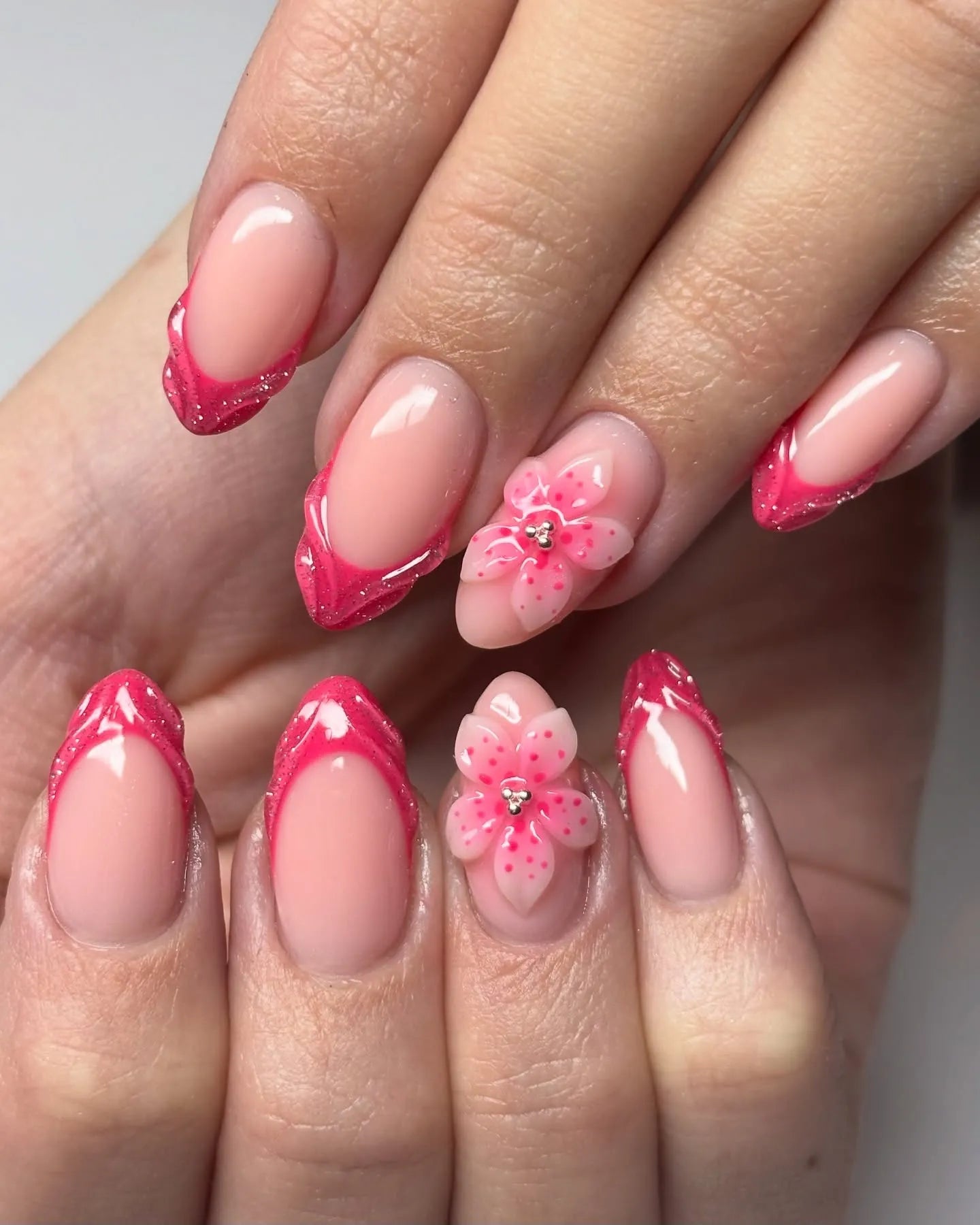 Handmade hot pink French tip press-on nails with 3D floral and glitter accents
