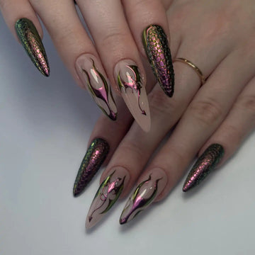 Hand with long stiletto press-on nails featuring iridescent dragon scale and gothic chrome designs.
