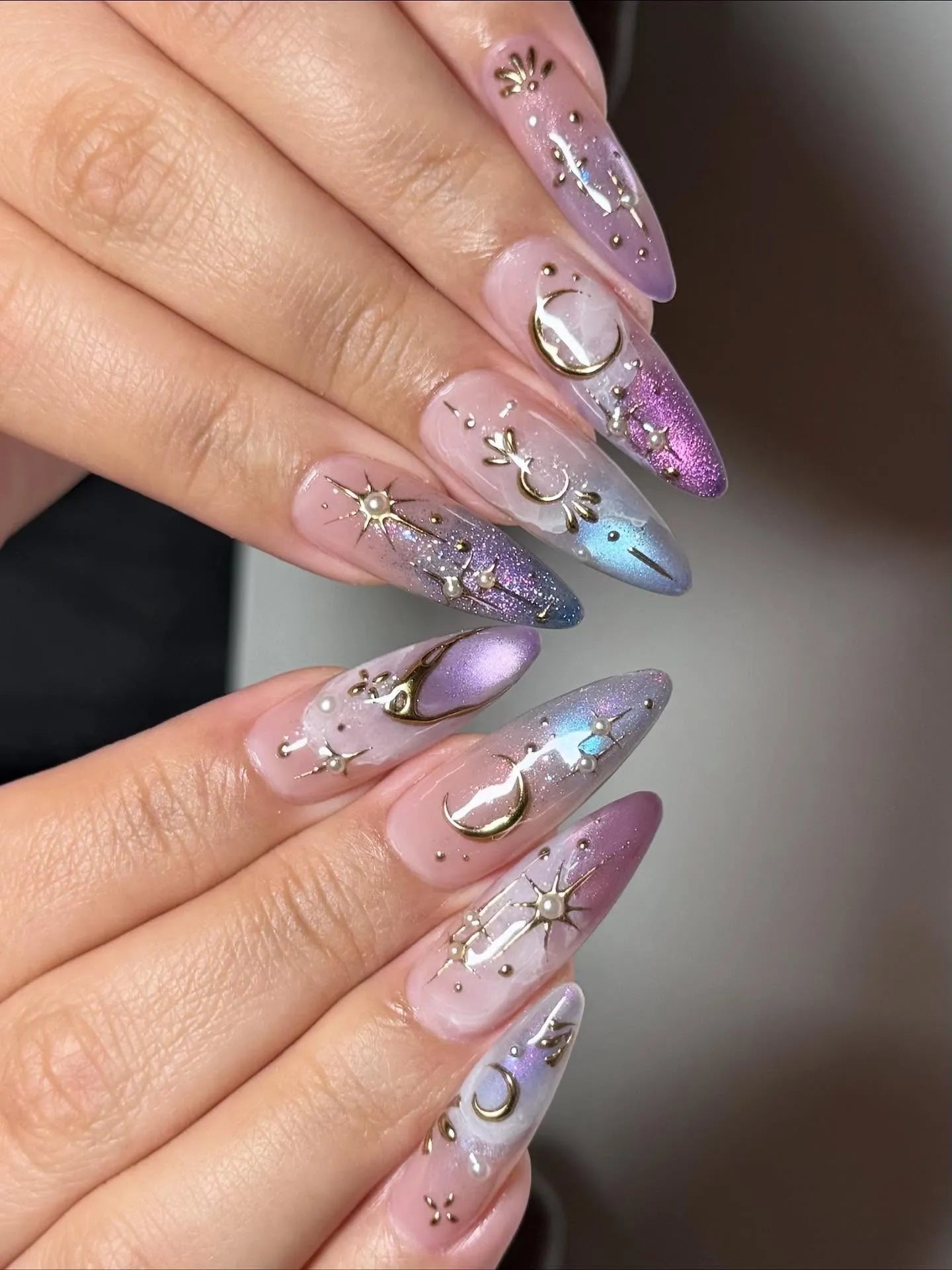 Handmade iridescent stiletto press-on nails with celestial moon and star nail art.